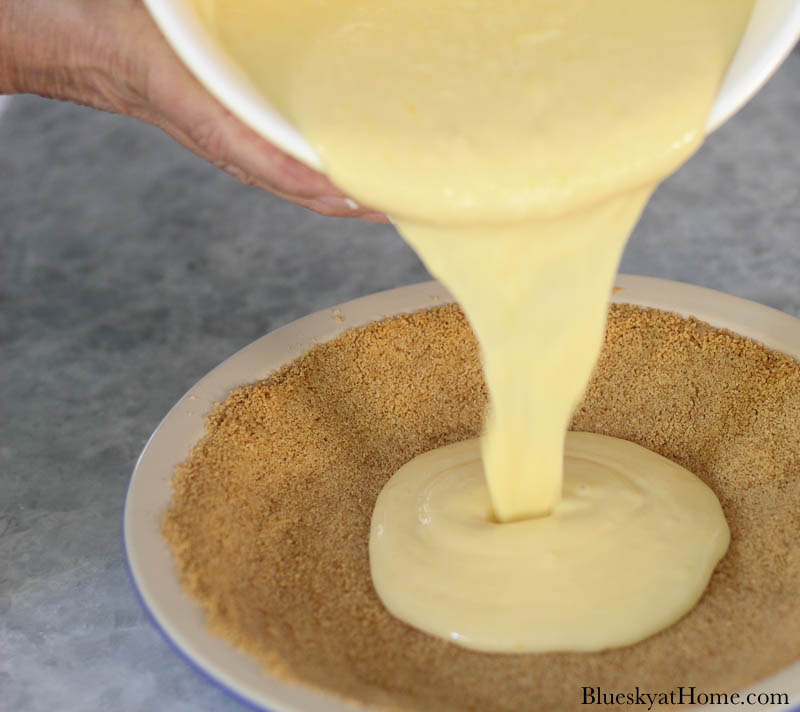 pouring lemon icebox pie filling into crust