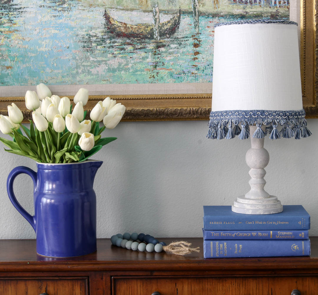 blue pitcher with white tulips and lamp