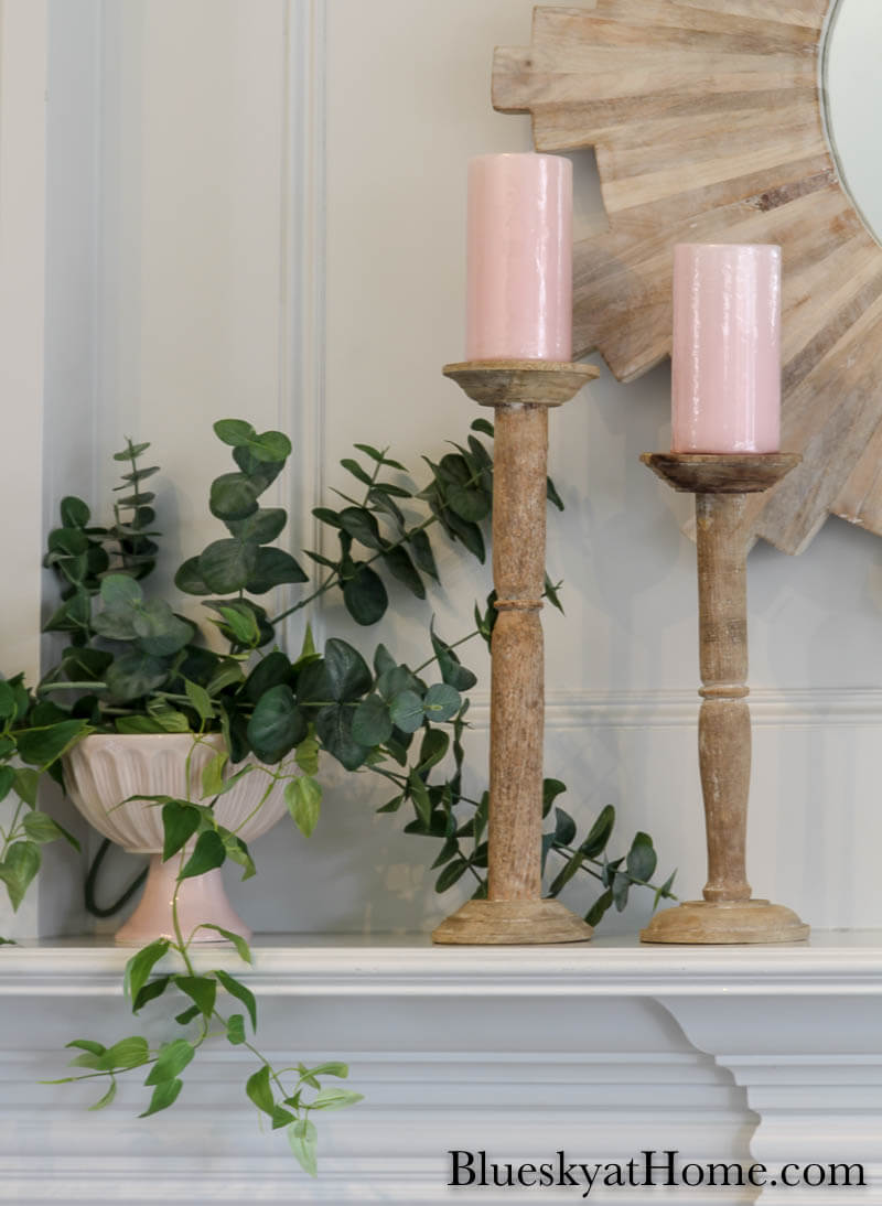 pink candles on wood cantlesticks