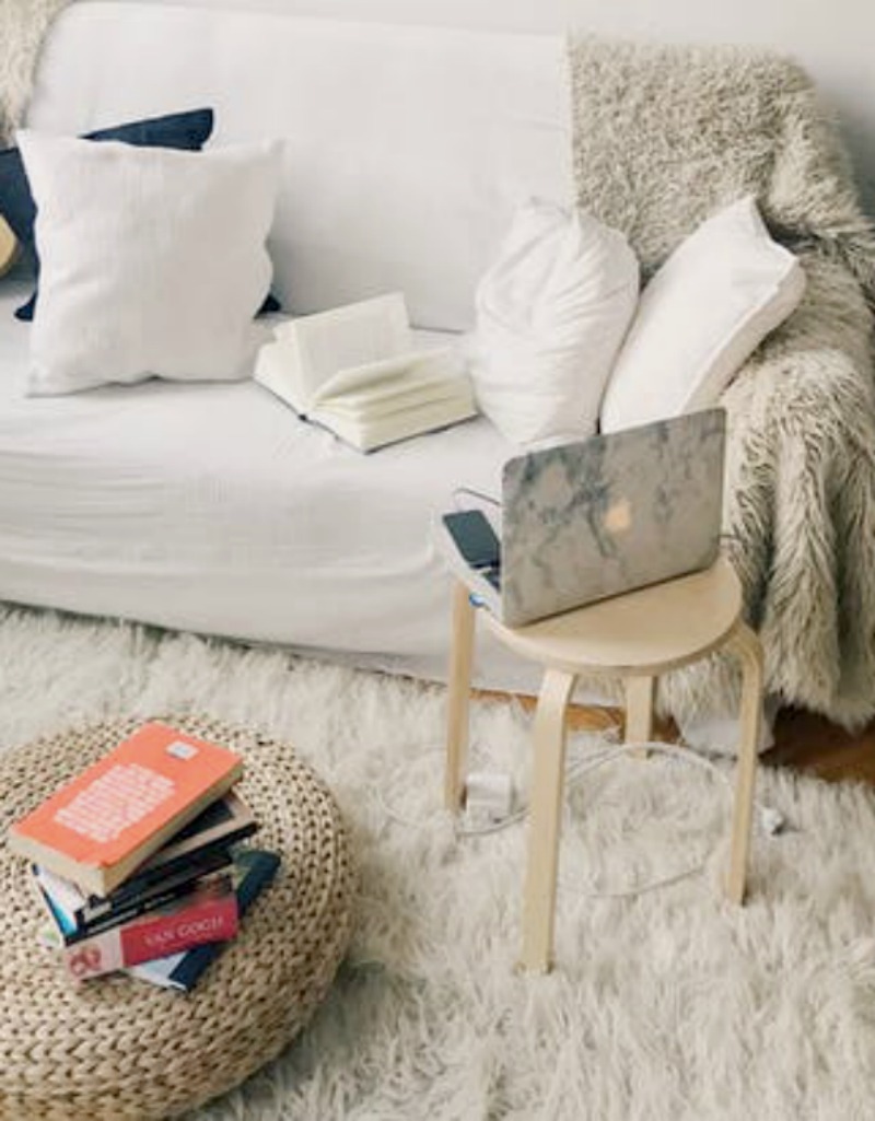 white sofa with gray blanket