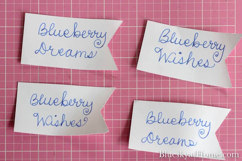 white paper pennants with blue writing