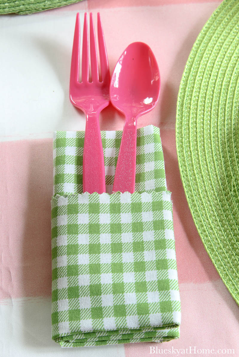green adn white checked napkin with pink fork and spoon
