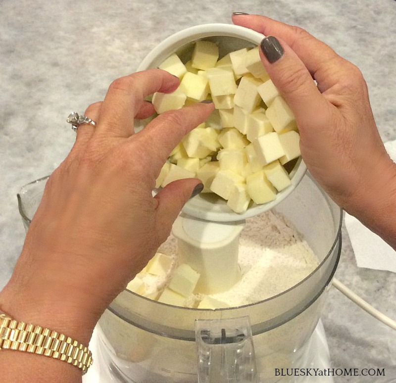 adding butter to food processor