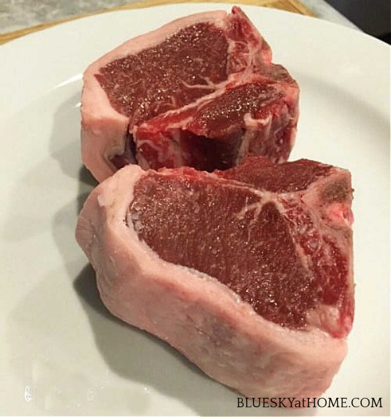 two lamb loin chops on a white plate