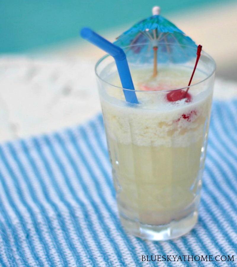 pina colada in tall glass with umbrella and cherry