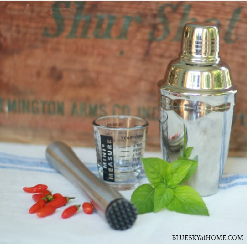 cocktail shaker and basil leaves and tabasco peppers