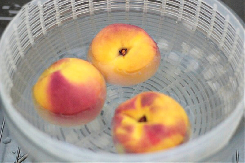 peaches in ice water in salad spinner