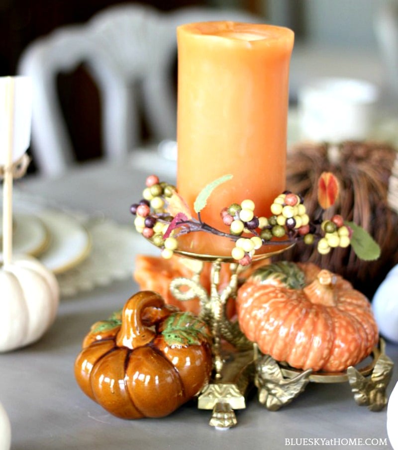 traditional autumn tablescape with orange candle and pumpkins