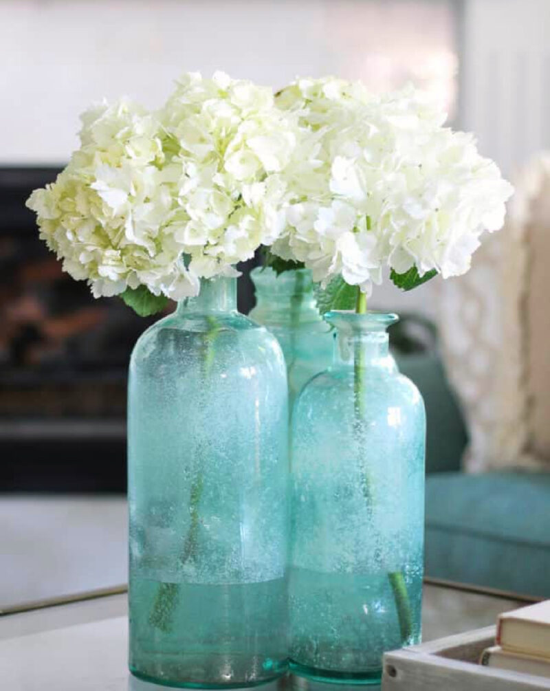 tall sea glass vases with white hydrangeas