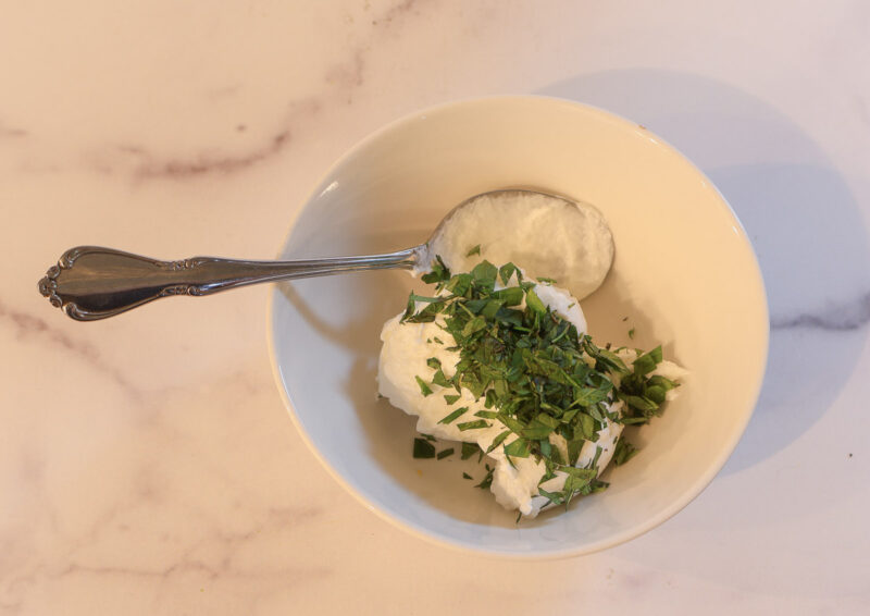 yogurt and mint in bowl with spoon
