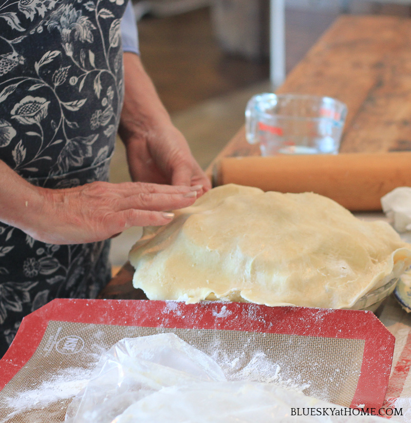 placing top dough on apple pie