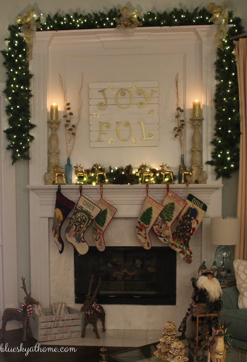 Decorating the Mantle with Lights and Garland for Christmas provides sparkle and magic. Reindeer and stockings add to the festive feel. BlueskyatHome.com