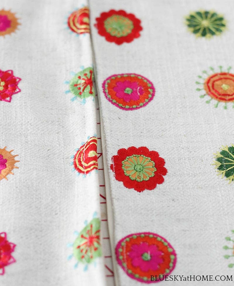 zipper and pink, green, orange embroidery circles on cream background