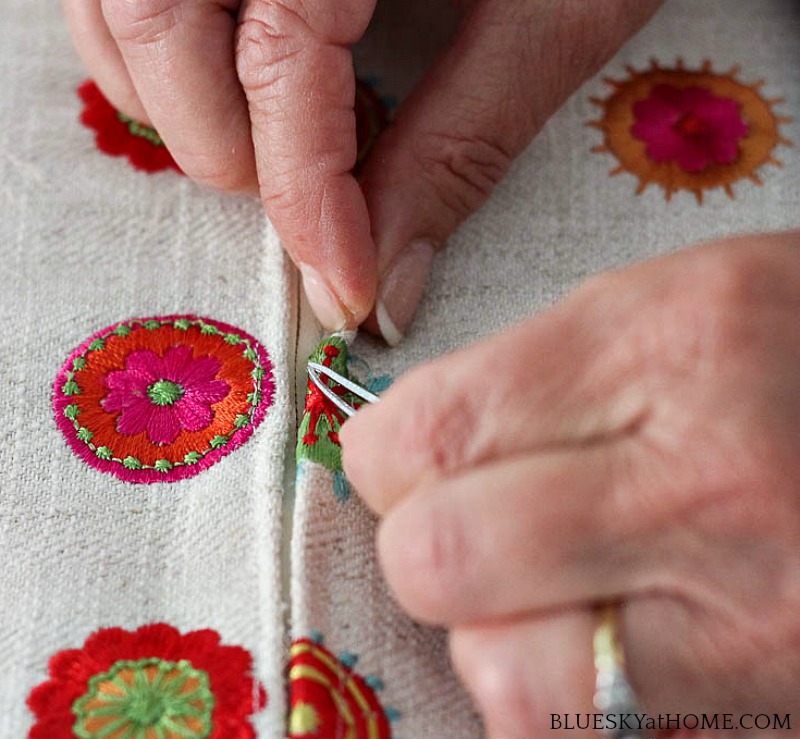 hands removing threads form fabric