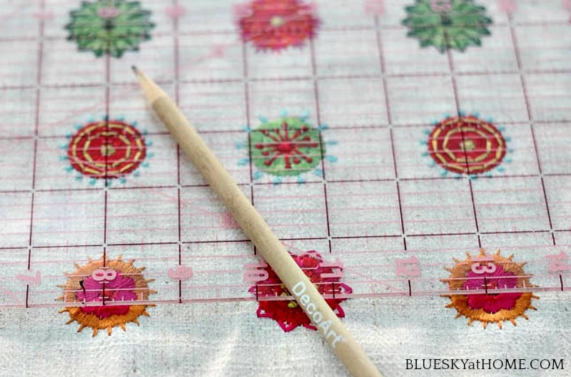 pink, green, orange embroidery circles on cream background with pencil