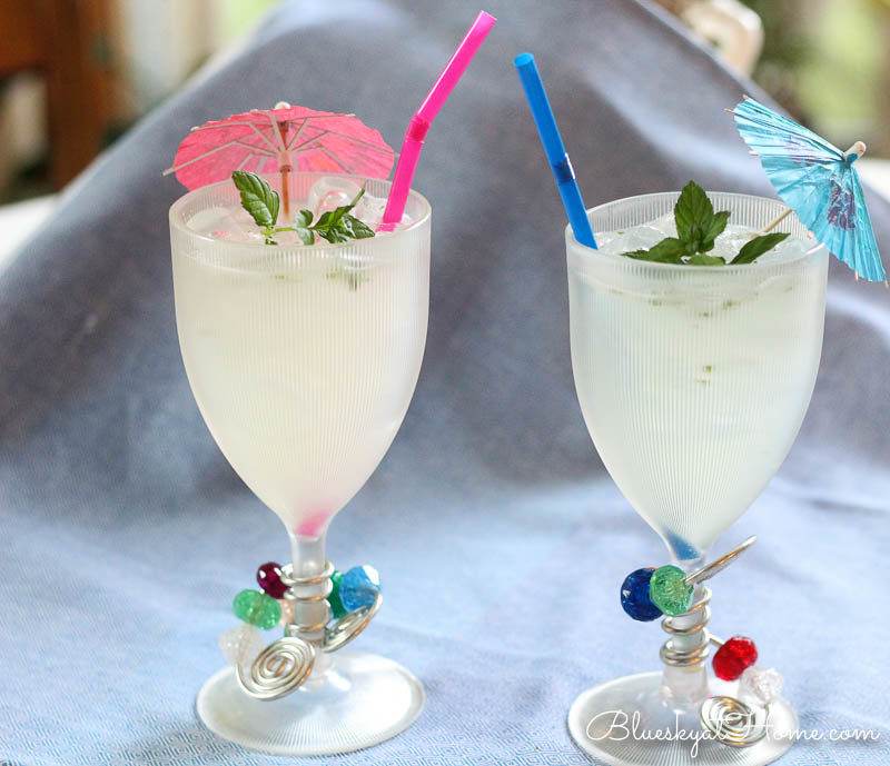 mojitos in glass with umbrellas and straws