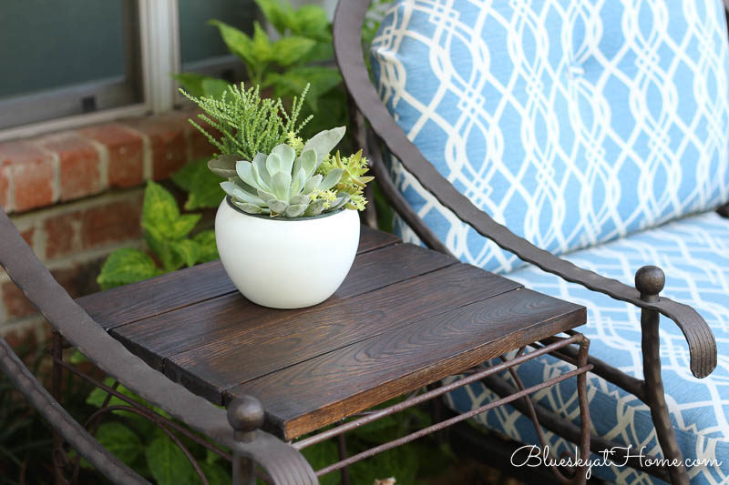 stained table top with plant and blue chair