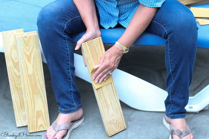 person sanding patio tabletops