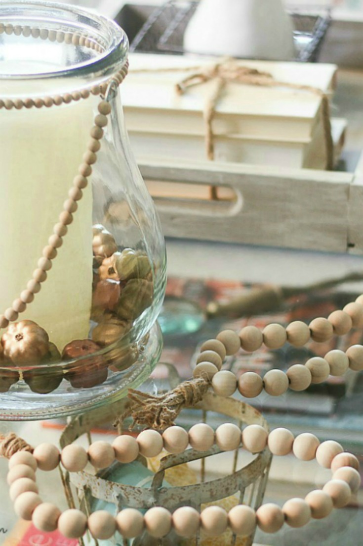 wooden beads and pumpkins in glass vase