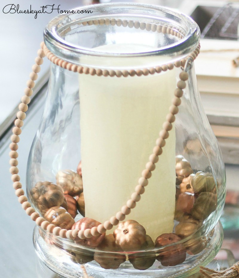 glass vase with metallic pumpkins