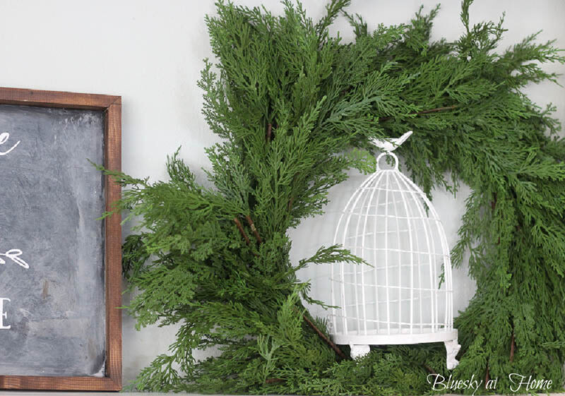 white birdcage with green wreath