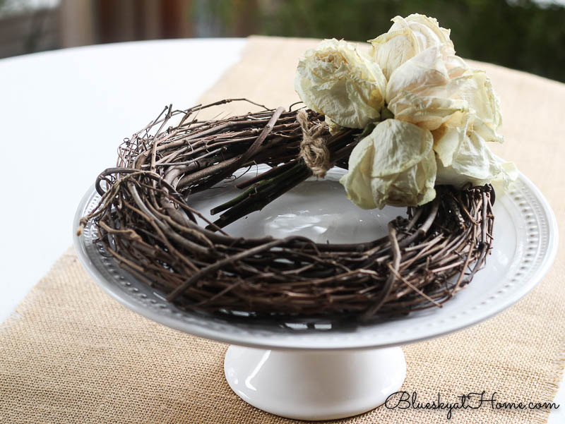 white cake stand, twig wreath and white roses