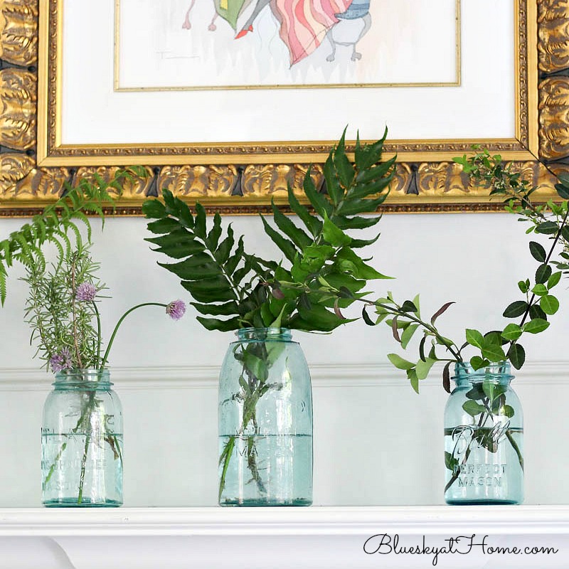 green in mason jars on mantle