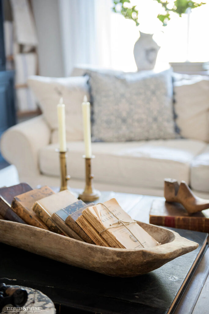 vintage books in a dough bowl on coffee table