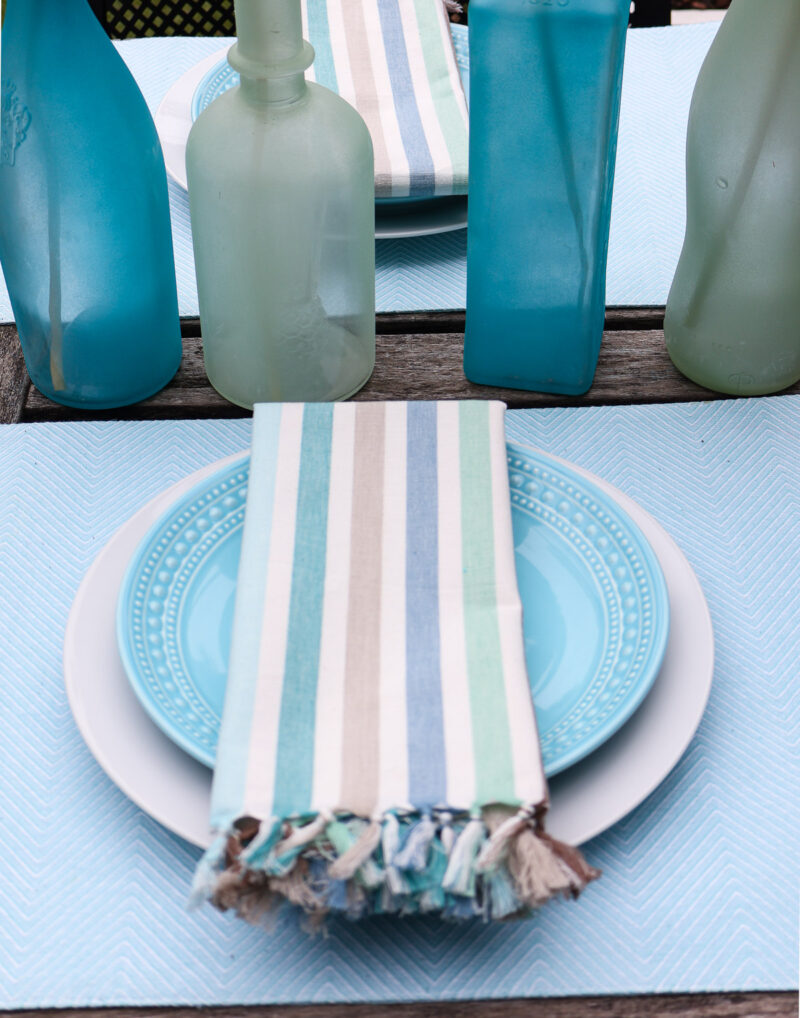 aqua platemat, whtie dinner plate, aqua salad plate, and stripe napkin