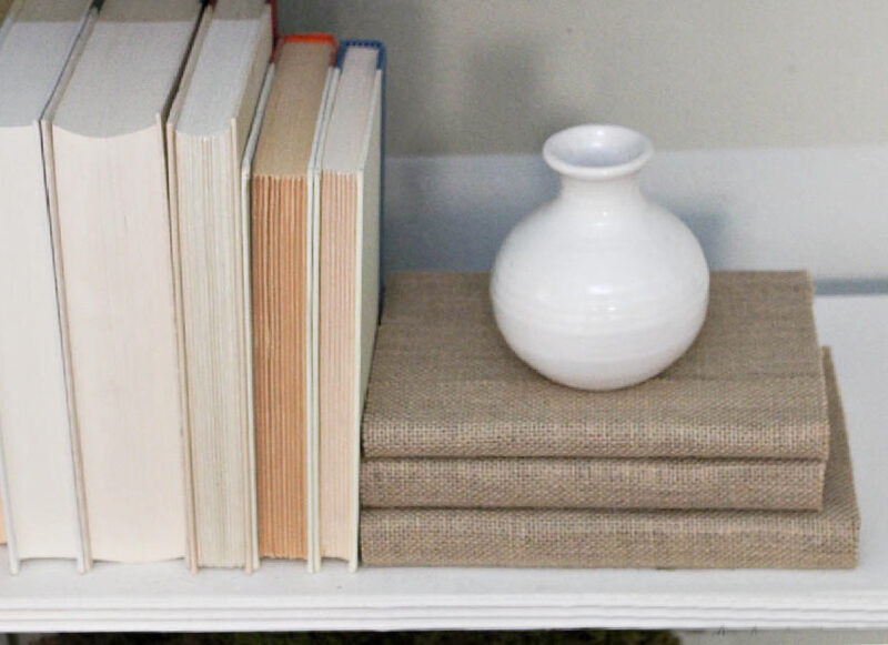 small shite vase and burlap-covered books and white book covers