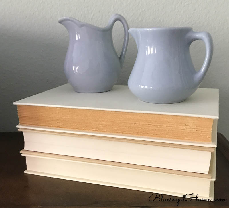 blue pitchers on white stacked books