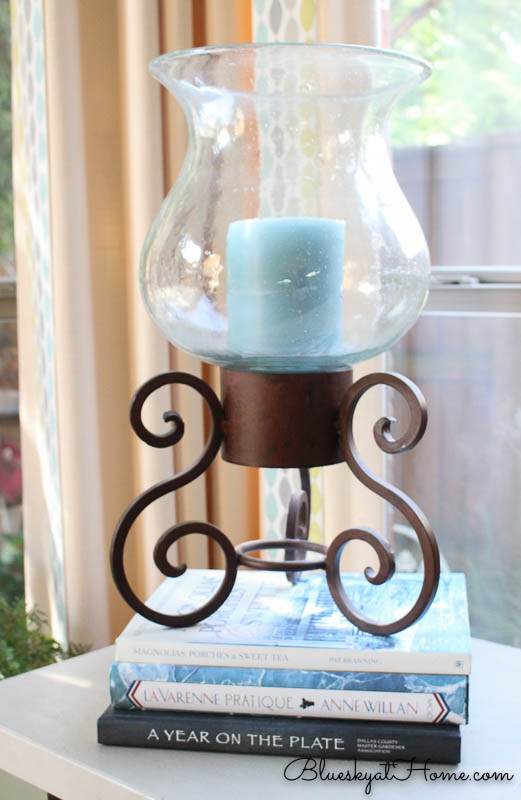 blue candle in holder on stack of books