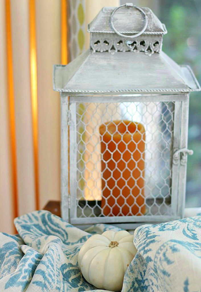 fall buffet table display with orange candle in metal lantern