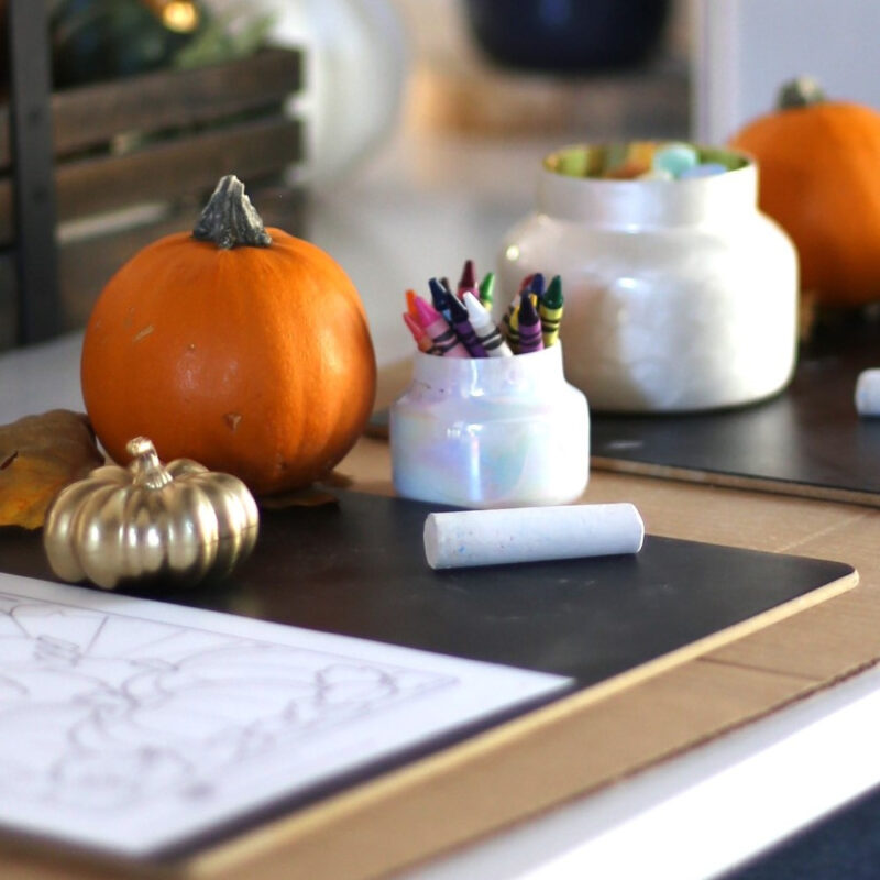 Thanksgiving table for kids with pumpkins and crayons