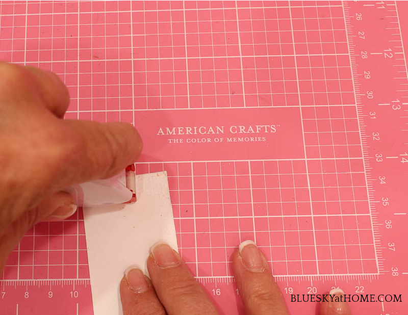 applying adhesive to holiday place cards