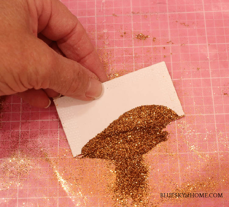 applying glitter to holiday place cards