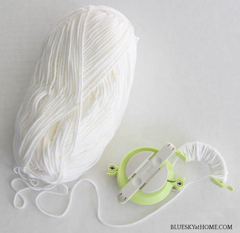 white yarn and pom-pom maker