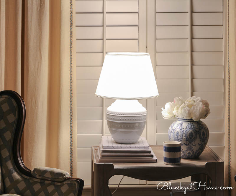 lamp and blue vase on table