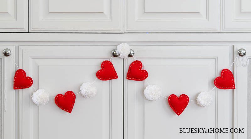 pom-pom heart garland on cabinet