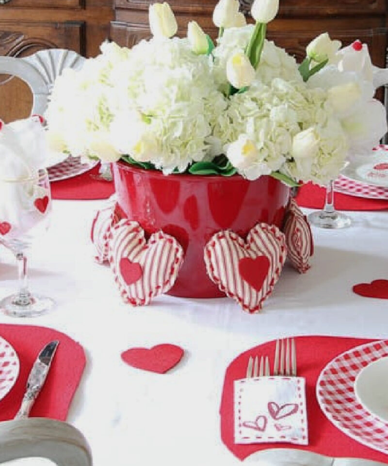 red and white valentine tablescape centerpiece with white hydrangeas and roses