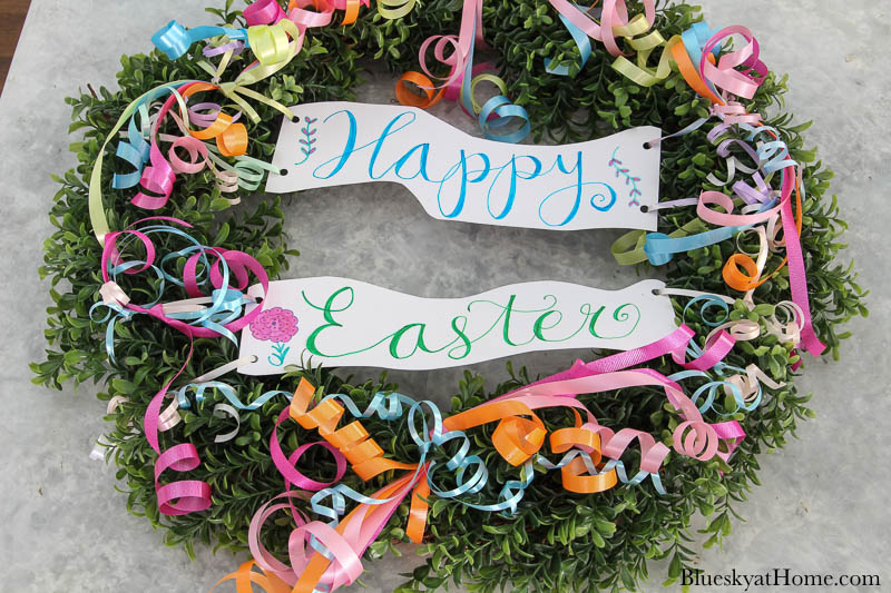 Happy Easter sign and curly ribbon on boxwood wreath