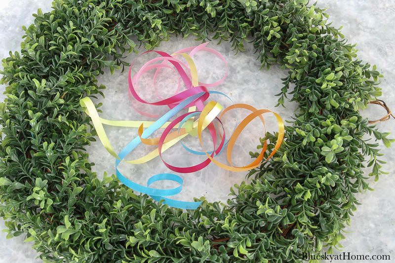 pieces of curly ribbon and boxwood wreath