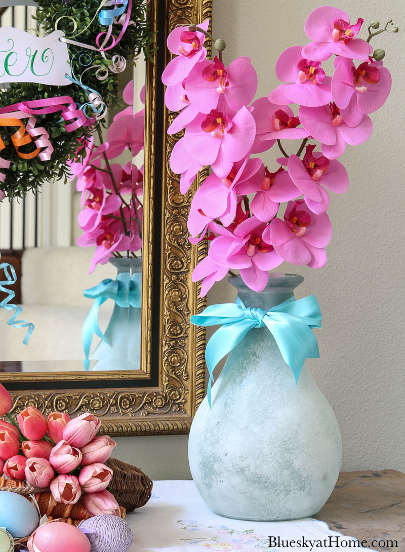 light blue vase with pink orchids