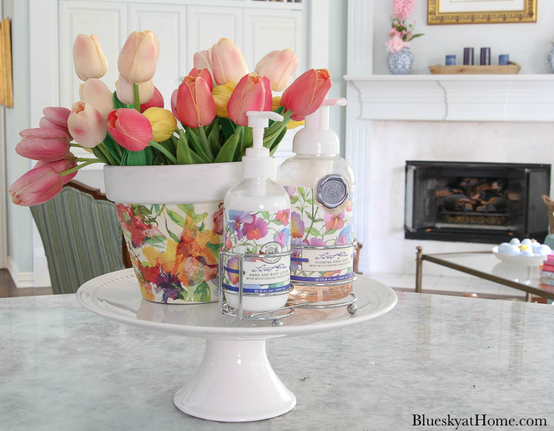 decorated terra pot with floral design and tulips on cake stand
