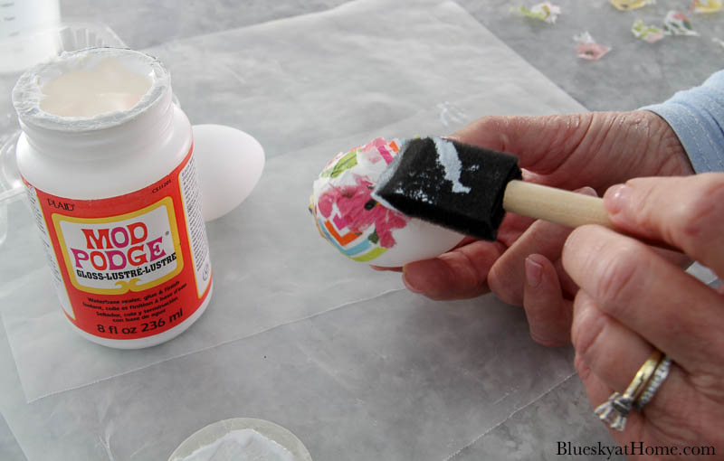 applying colored napkins to easter egg