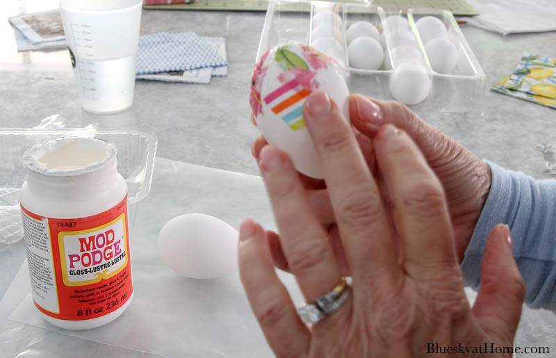 applying colored napkins to easter egg