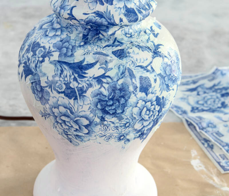 applying pieces of napkin to lamp with decoupage