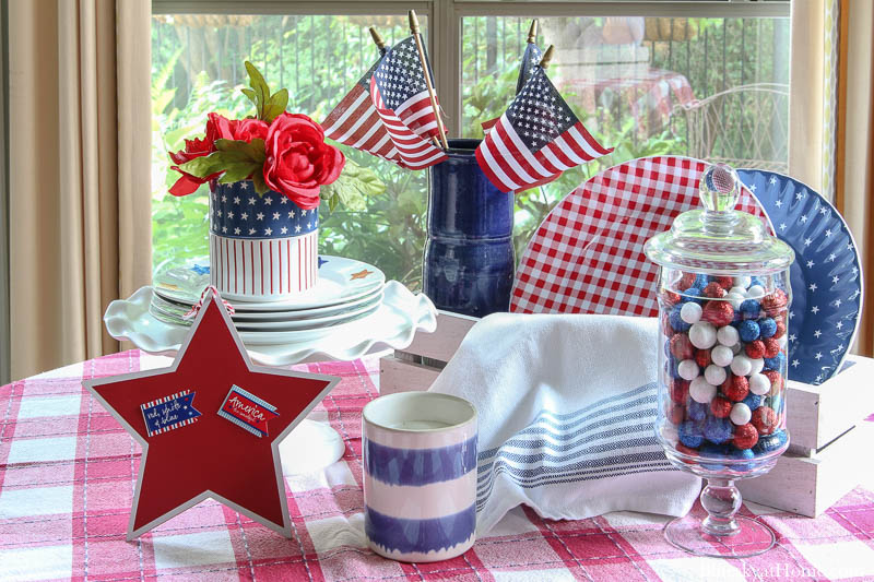 blue plates with stars and red check plates with red check dishtowel and apothecary jar with red, white and blue balls