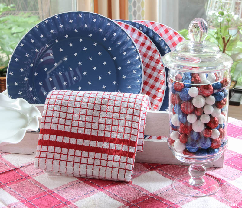 blue plates with stars and red check plates with red check dishtowel and apothecary jar with red, white and blue balls