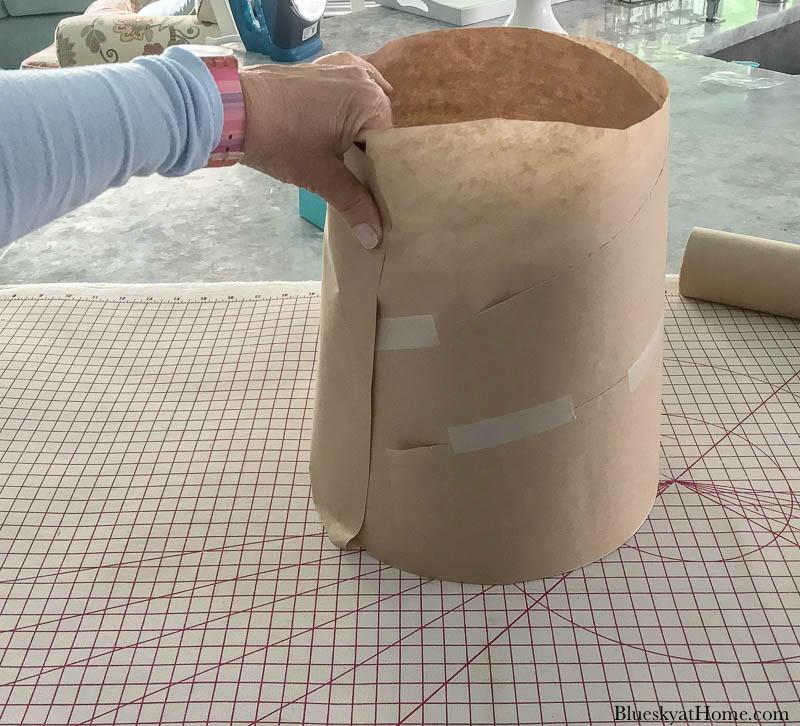 hand holding brown craft paper around lamp shade